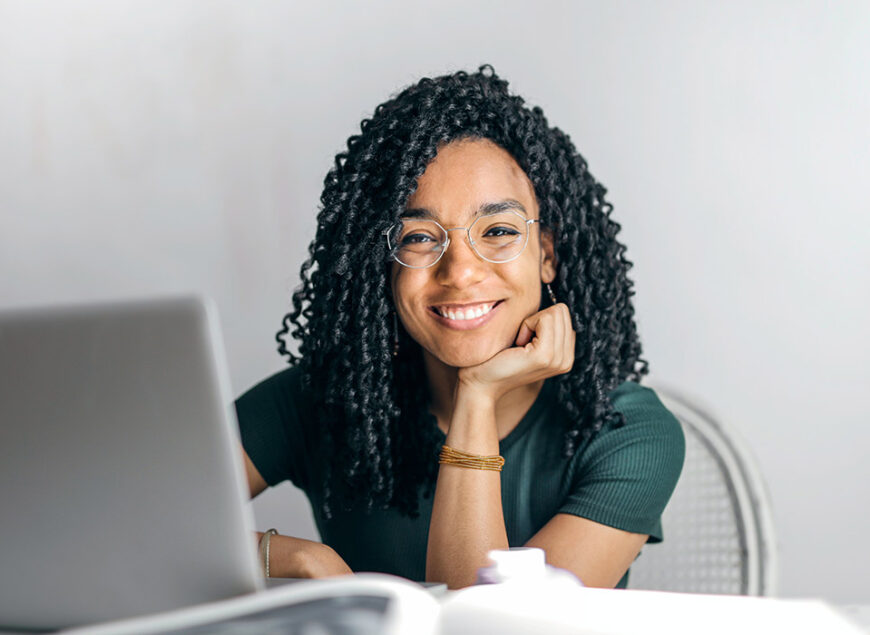 Smiling woman with curly hair at laptop