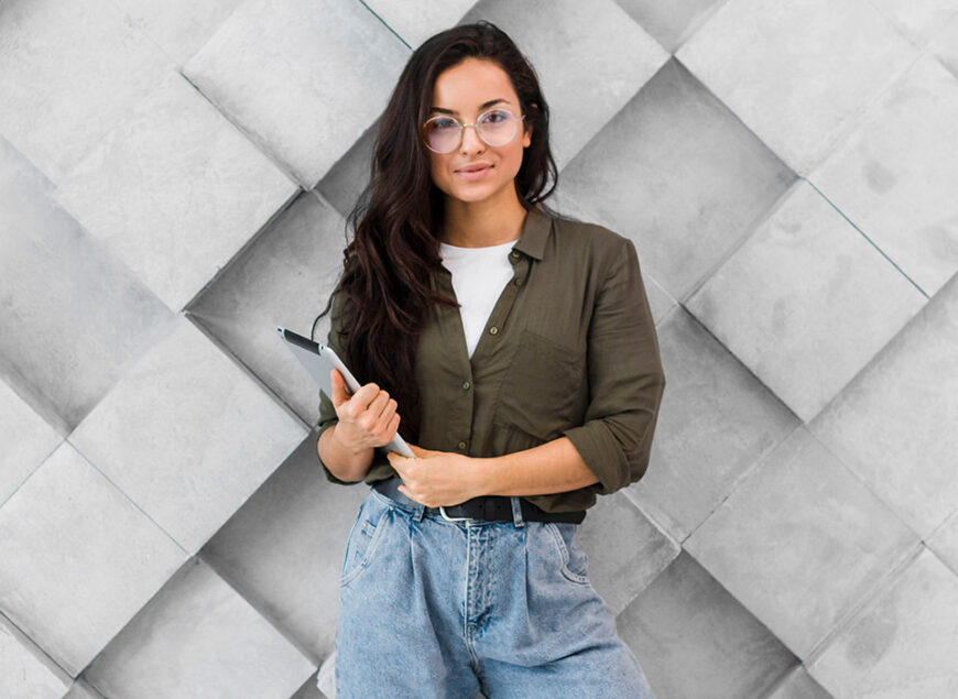 Woman with tablet by geometric concrete wall