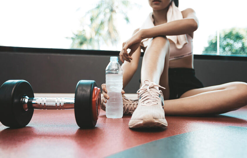 Person resting with dumbbell and water bottle