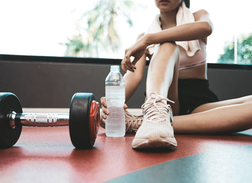 Person resting with dumbbell and water bottle